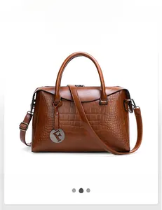 Macro detail of brown crocodile pattern leather with F-shaped metallic charm