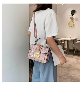 Pink snake pattern crossbody bag with gold chain and metal lock worn by a model