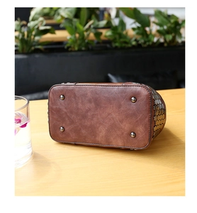Detail of vintage brown leather bag base with four silver metal feet and rivet accents