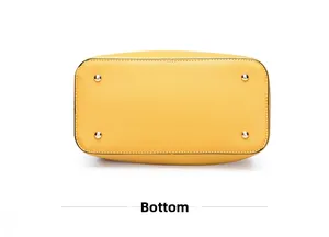 Detail view of the yellow leather bag bottom with four protective gold metal feet