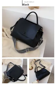 Detail view of black faux leather tote featuring a geometric patterned wide strap