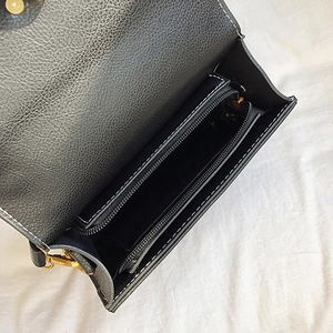 Top view of black pebbled leather handbag interior with gold zipper pocket and main compartment
