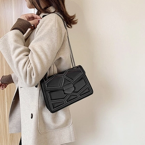 Fashionable black quilted crossbody bag with silver studs and metal chain strap