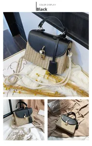 Detail view of vintage straw woven handbag featuring black leather trim and flower accent