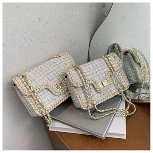Détail du sac à chaîne en tweed blanc avec fermoir pivotant doré et texture tissée