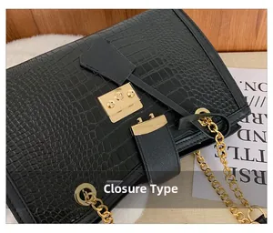 Detail of crocodile pattern shoulder bag with golden chain and metallic buckle lock