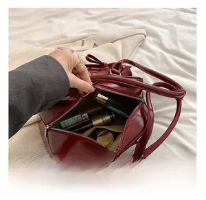 Interior view of the deep red patent leather shoulder bag showing large storage capacity