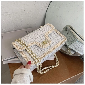 Détail du sac en tweed à chaîne avec fermoir doré et bordure tissée élégante