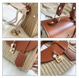 Detailed close-up of straw woven handbag with leather flap and metal clasp closure