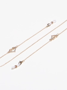 Détail de chaîne à lunettes dorée avec pendentifs cœur infini strass et boucles en caoutchouc