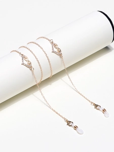 Détail de la chaîne dorée avec cœur en strass et symboles infini pour lunettes