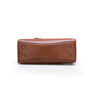 Bottom view of brown crocodile embossed leather tote bag with four protective metal studs