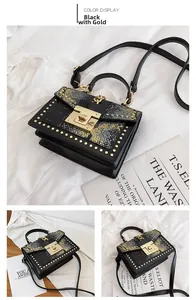 Detail view of black and snakeskin textured handbag with gold studs and clasp