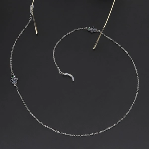Silver chain eyewear strap with Hamsa Hand and Evil Eye charms on black background