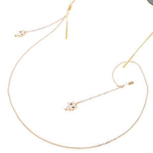 Détail de la chaîne de lunettes dorée avec pendentifs chat blanc et boucles réglables