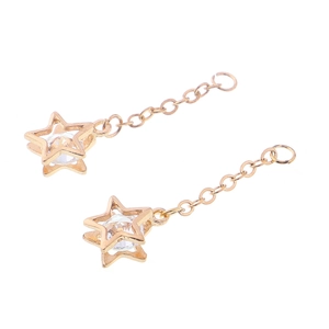 Détail de boucles d'oreilles étoile dorées avec cadre ajouré et pierre zircon brillante