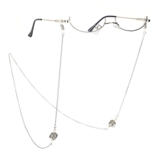 Détail de la chaîne à lunettes argentée avec sphères de cristal et perles sur la monture
