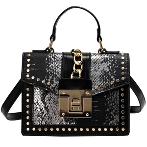 Snake pattern handbag with silver and black panels, gold rivets, and chain decoration