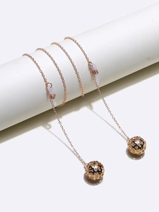 Detail of rose gold eyewear chain with hollow sphere pendants and silicone loops