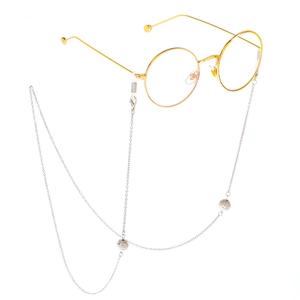 Lunettes rondes dorées tendance avec chaîne à billes argentées sur fond blanc