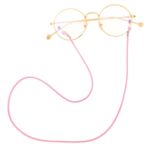 Close-up of pink woven eyewear cord with non-slip rubber ends on golden glasses