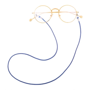 Close-up of the woven texture on the blue eyewear cord and gold metal frame details