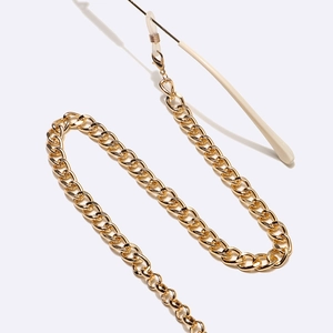 Detail of chunky gold metal glasses chain showing non-slip silicone loops and metal springs