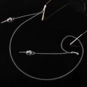 Détail de la chaîne de lunettes en métal argenté avec pendentifs crâne d'oiseau