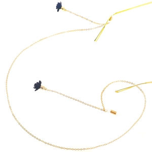 Goldene Brillenkette aus Metall mit schwarzen Samtblüten und Silikonschlaufen auf Weiß