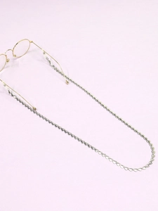 Detail showing silver stainless steel heart-link chain attached to glasses on lilac background