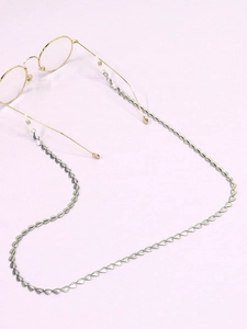 Detail of silver heart-shaped link eyewear chain with anti-slip silicone loops on glasses