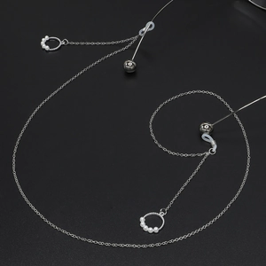 Silver eyewear chain with round pearl pendants and non-slip silicone loops on black background