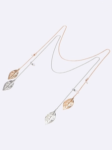 Detail of silver and gold metal eyewear chains with intricate leaf pendants and silicone loops