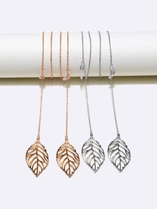 Silver and gold leaf eyewear chains with non-slip silicone loops on a minimalist stand