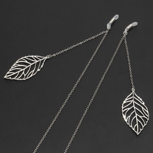 Silver metal glasses chain with leaf pendants and anti-slip rings on black background