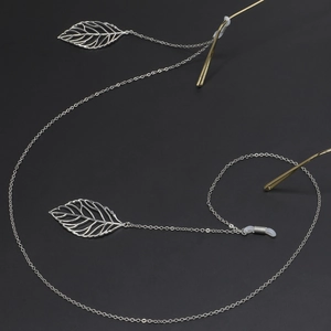 Silver eyewear chain featuring hollow leaf pendants and anti-slip silicone loops