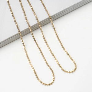Polished gold beaded sun glasses chain with metallic luster on white background