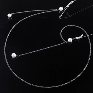 Elegant silver metal eyeglasses chain with white faux pearls on reflective black surface