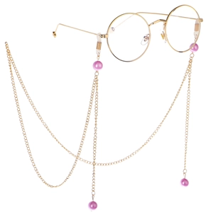 Set de lunettes rondes dorées avec chaîne élégante en perles sur fond blanc pur