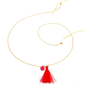 Chaîne à lunettes dorée avec pendentif smiley rose et un pompon rouge vif élégant
