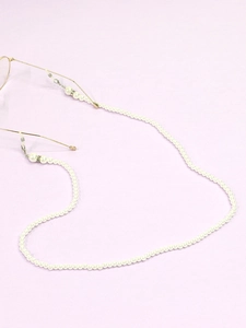 Detail of elegant pearl eyeglass chain with white beads and rubber loops for glasses