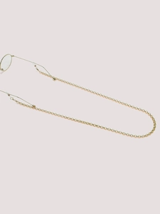 Detail of gold chain glasses strap with silicone loops and round metallic link texture