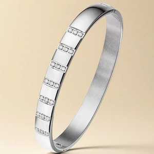 Detailed macro view of silver stainless steel bangle with set zircons and brushed metal texture