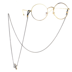 Round gold metal glasses with a minimalist chain featuring black and white flower charms