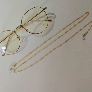 Detailed view of golden metal eyeglass chain with transparent silicone anti-slip loops