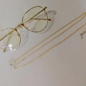 Golden metal chain for sunglasses with clear silicone anti-slip loops on gray background