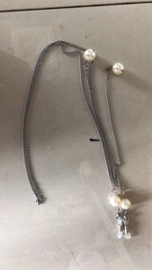 Détail de la chaîne de lunettes argentée avec perles blanches et anneaux en silicone