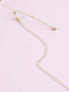 Detail of handmade white pearl eyewear chain with gold lobster clasp and rubber connector