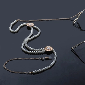 Chaîne à lunettes élégante en perles et or avec ornements floraux sur fond noir