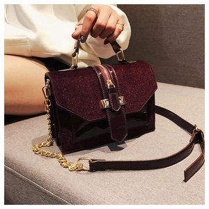 Details der burgunderroten Handtasche mit Lackoberfläche und goldener Kette